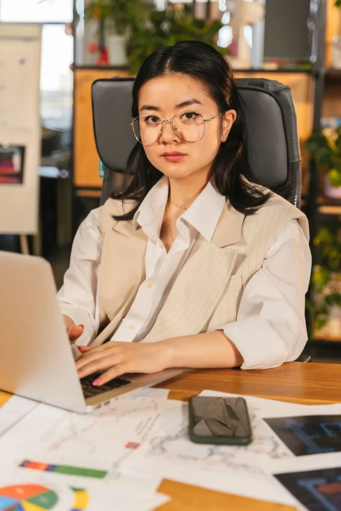 Cara memilih website builder, perempuan menguji demo di laptop kantor