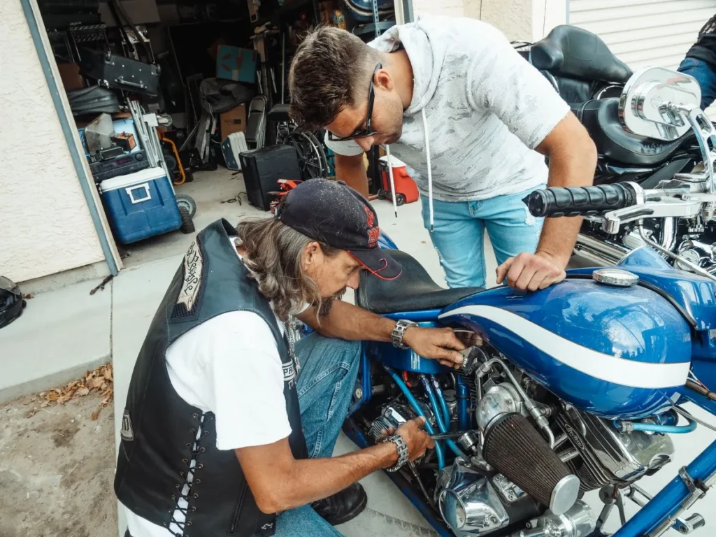 Mekanik memperbaiki motor di bengkel