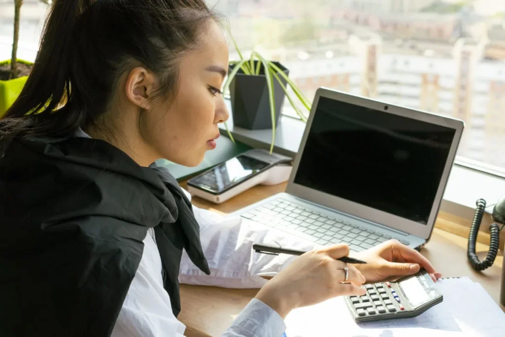 Harga jasa pembuatan website, pemilik usaha menghitung anggaran website di laptop