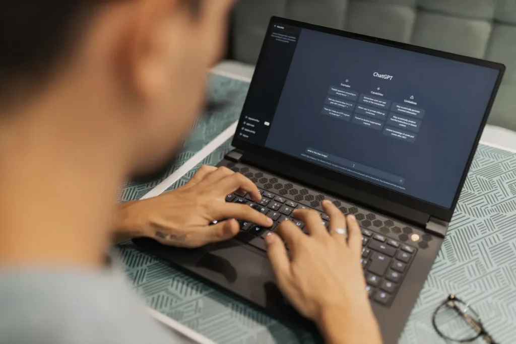 Kelebihan AI website builder, seseorang mengetik di laptop dengan software AI