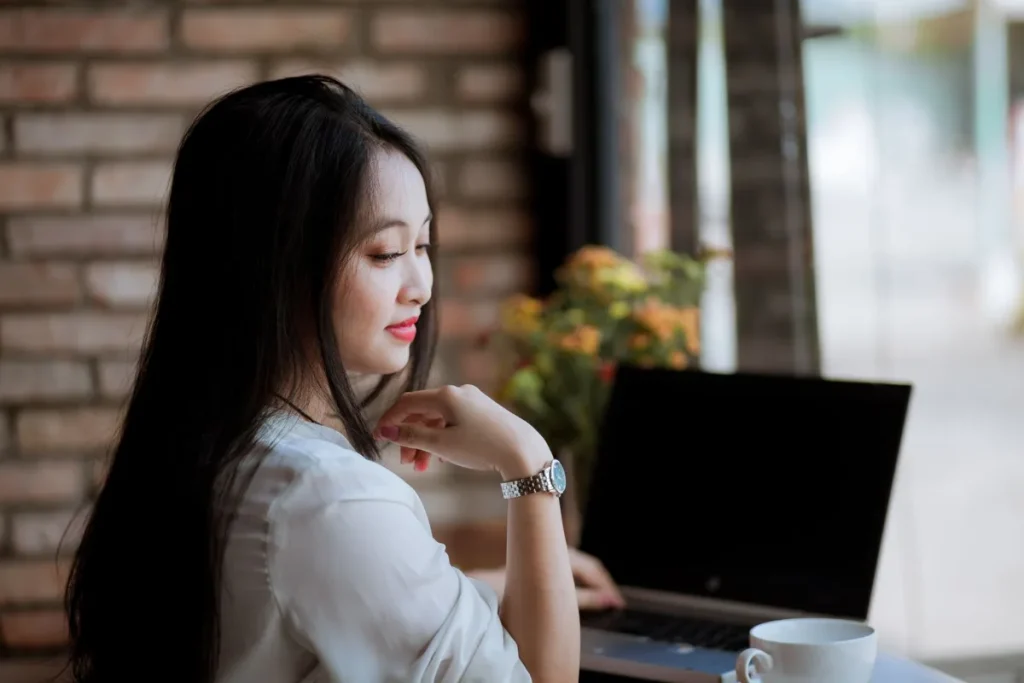 Kelebihan website builder, perempuan mengedit situs dari kafe